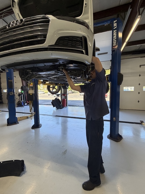 Joel, Audi technician working on a car in the shop